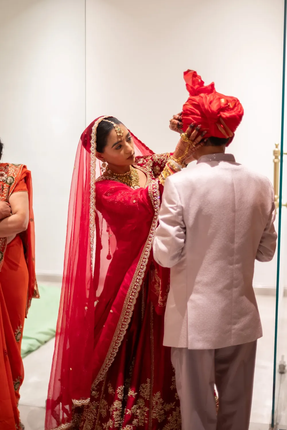 Bride in a red saree and groom in a red turban during their wedding, photographed by SRK Portraits