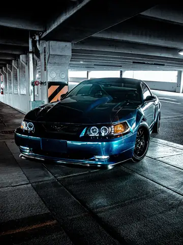 Blue performance car in a shadowed parking structure