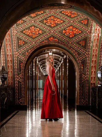 Woman in a red dress in an ornate Art Deco hallway