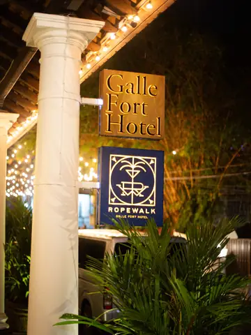 Galle Fort Hotel sign beside a white column at night