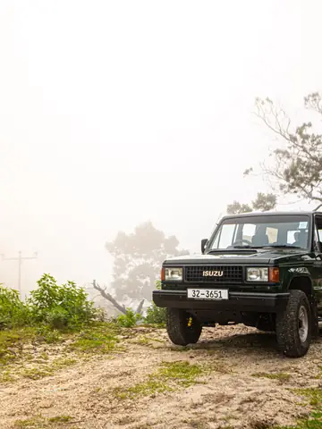 Jeep parked on a misty hilltop
