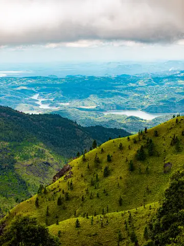 View over green hills and a valley under low cloud