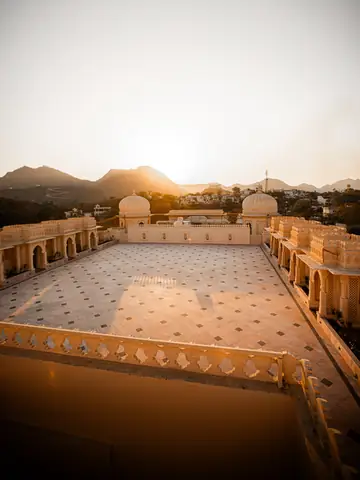 Palace terrace and domed pavilions at sunset with hills beyond