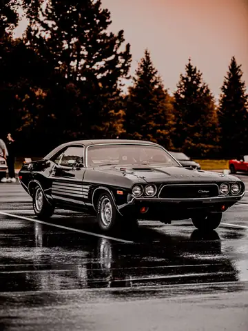 Classic black Dodge Challenger on wet asphalt