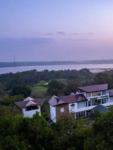 Aerial view of a white villa among trees near a lake