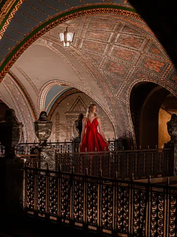 Woman in a dramatic red gown inside an ornate interior