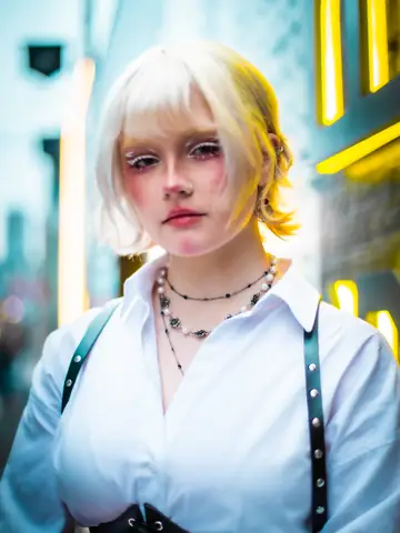 Close portrait of a platinum-haired woman lit by neon signs in Tokyo