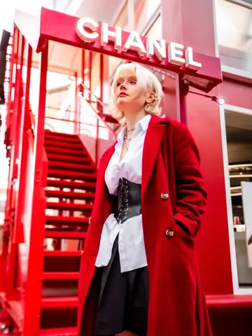 Woman with platinum hair in a long red coat on a red spiral staircase in Tokyo