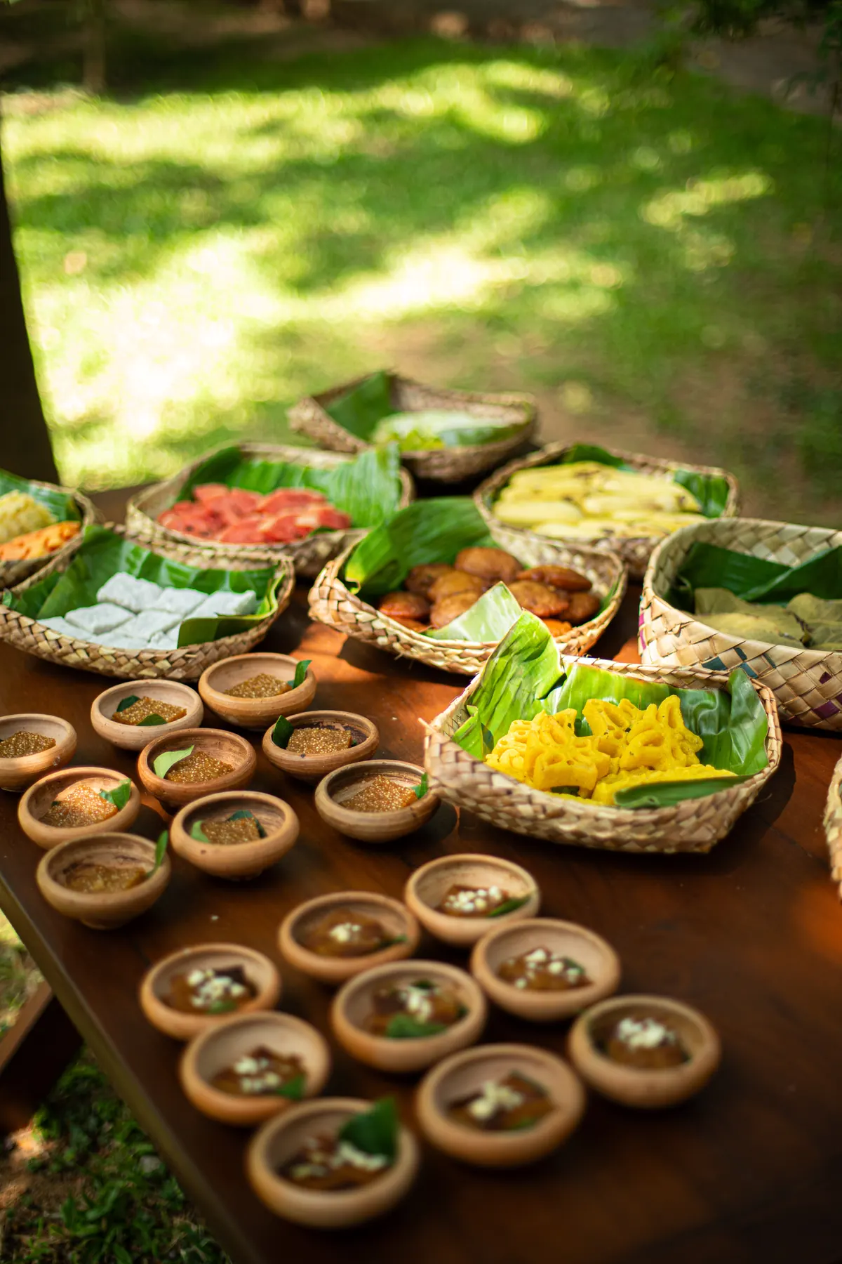 Colourful spread of small dishes in clay bowls on a wooden table