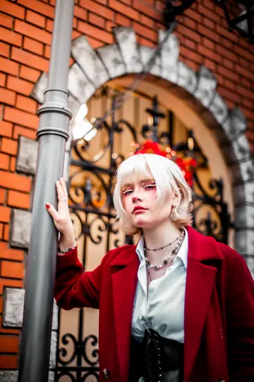 Ylva Brandt in a red coat at an arched brick doorway